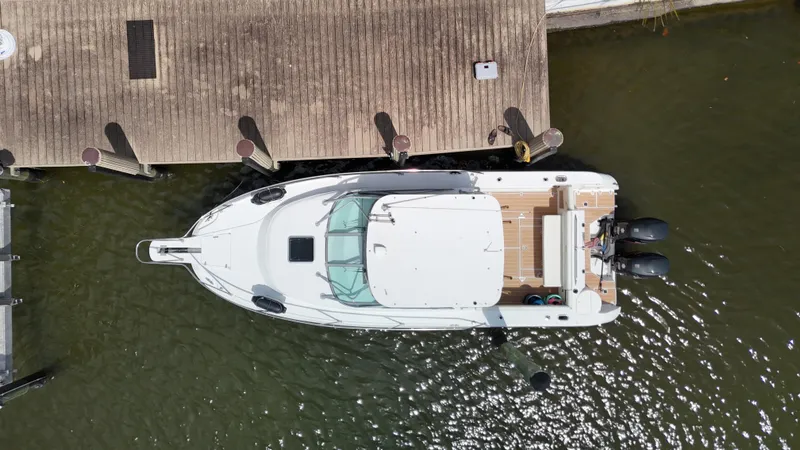 Slide: The Image of Overhead view of a 1999 Boston Whaler 28 Conquest docked at a wooden pier. - 33