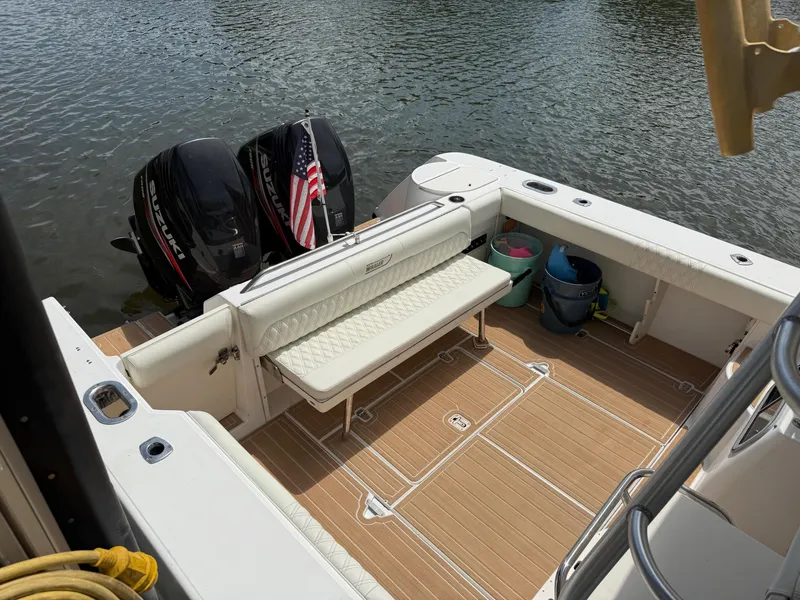 Slide: The Image of 1999 Boston Whaler 28 Conquest boat with twin engines and American flag on calm water. - 5