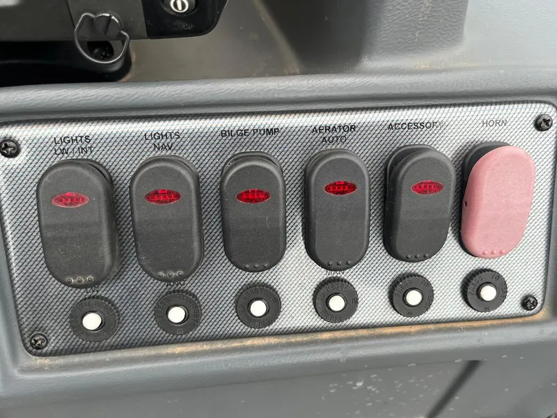 Slide: The Image of Control panel of a 2010 Alumacraft Navigator 175 CS boat with labeled switches. - 16
