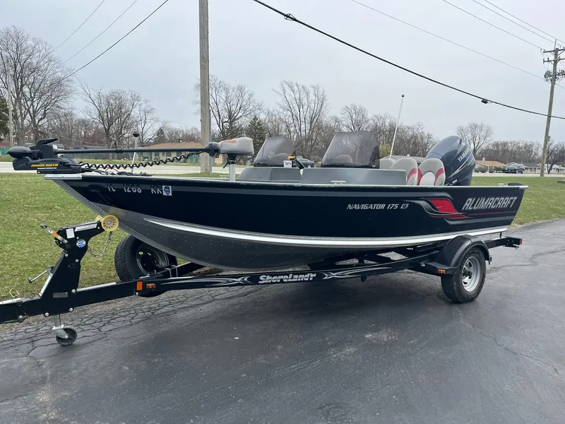 Slide: The Image of 2010 Alumacraft Navigator 175 CS boat on trailer, parked outdoors. - 3