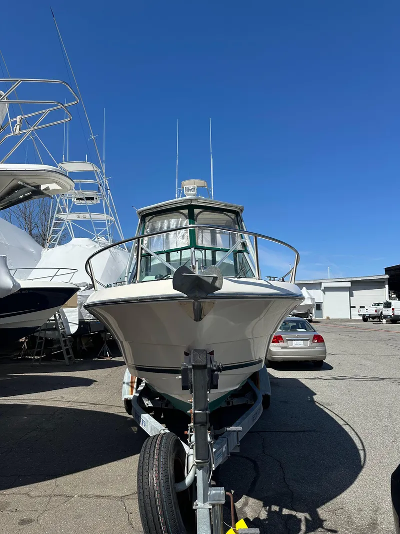Slide: The Image of 1998 Pursuit 2460 Denali boat on trailer under clear blue sky. - 1