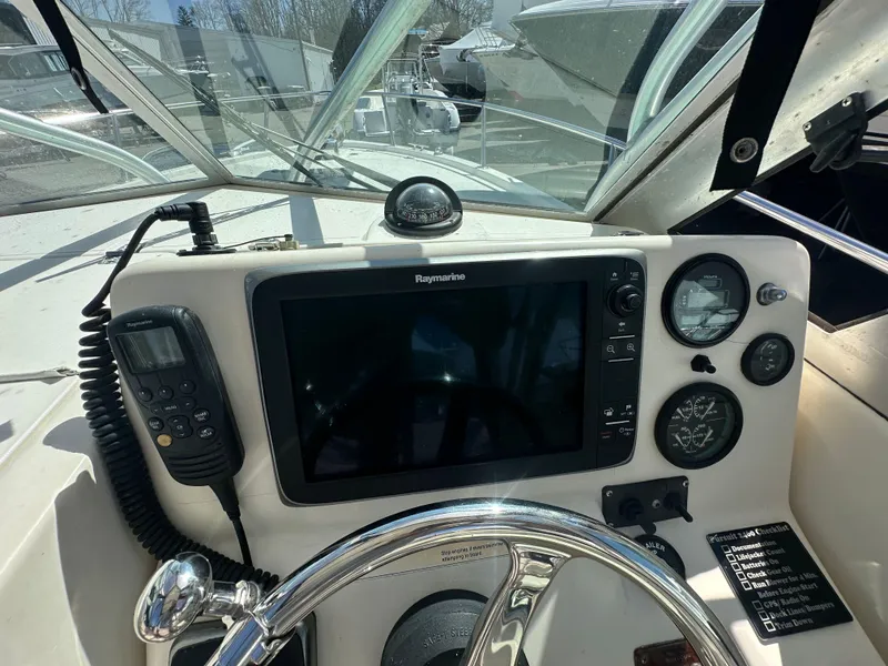 Slide: The Image of 1998 Pursuit 2460 Denali boat dashboard with navigation equipment and steering wheel. - 6