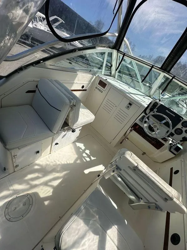 Slide: The Image of 1998 Pursuit 2460 Denali boat interior with steering wheel and seating. - 7