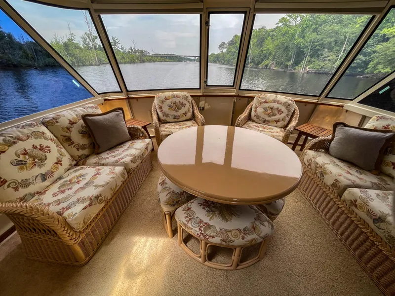 Slide: The Image of Luxurious 1984 Hatteras 53 Motoryacht interior with elegant seating and river view. - 14