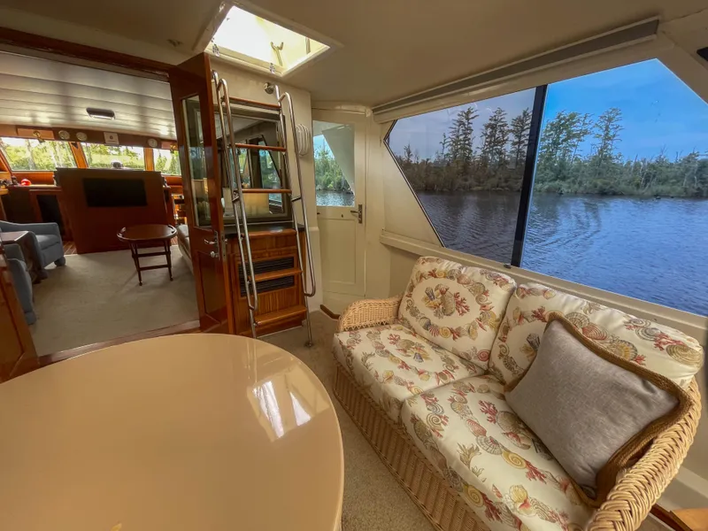 Slide: The Image of Interior of 1984 Hatteras 53 Motoryacht with floral sofa, river view, and elegant wood finishes. - 18