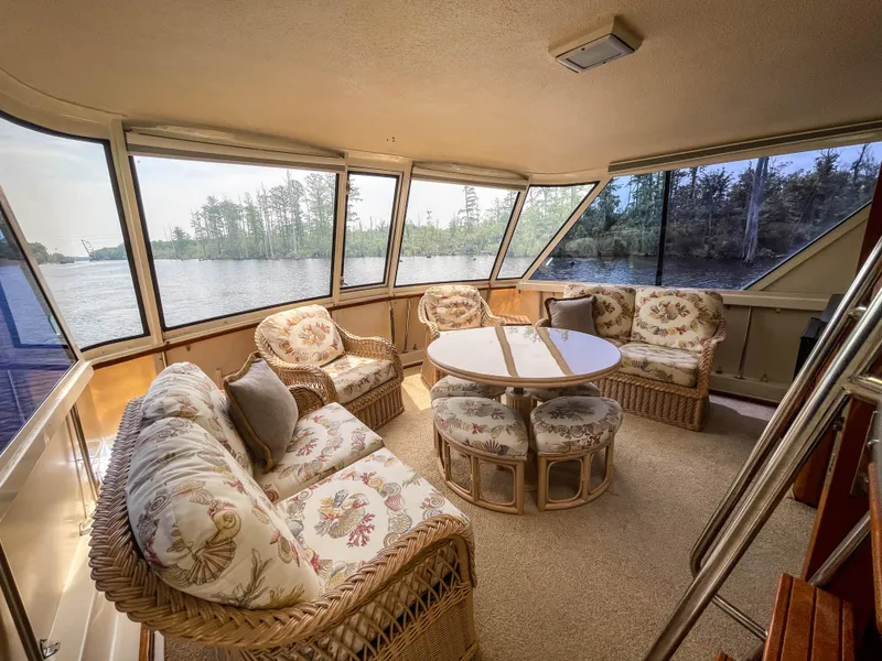 Slide: The Image of Interior of 1984 Hatteras 53 Motoryacht with wicker furniture and panoramic windows. - 19