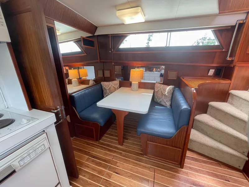 Slide: The Image of Interior of 1984 Hatteras 53 Motoryacht with dining area and wooden flooring. - 21