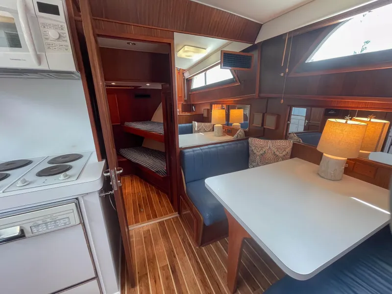 Slide: The Image of Interior of 1984 Hatteras 53 Motoryacht with dining area, kitchen, and cozy cabin. - 24
