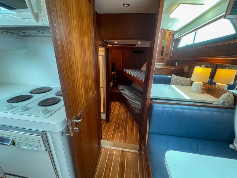 Slide: The Image of Interior of 1984 Hatteras 53 Motoryacht with wood paneling, bunk beds, and kitchen area. - 25