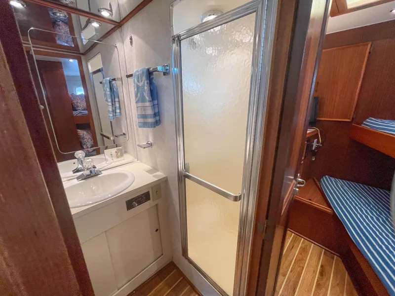 Slide: The Image of 1984 Hatteras 53 Motoryacht bathroom with shower, sink, and wooden flooring. - 29