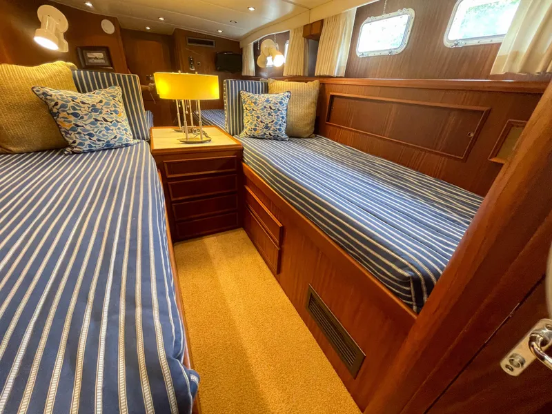 Slide: The Image of Interior of 1984 Hatteras 53 Motoryacht with twin beds and striped bedding. - 34