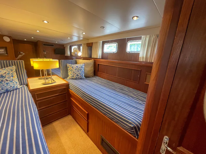 Slide: The Image of Interior of 1984 Hatteras 53 Motoryacht with twin beds and striped bedding. - 36