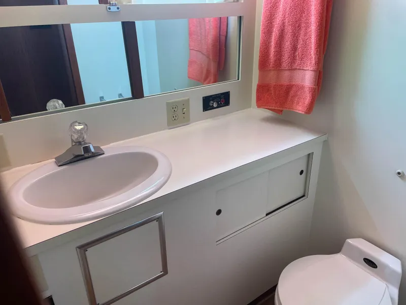 Slide: The Image of 1984 Hatteras 53 Motoryacht bathroom with sink, mirror, and red towel. - 42