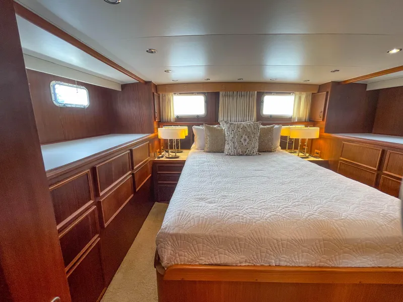 Slide: The Image of Luxurious bedroom interior of 1984 Hatteras 53 Motoryacht with wood paneling and cozy bedding. - 46