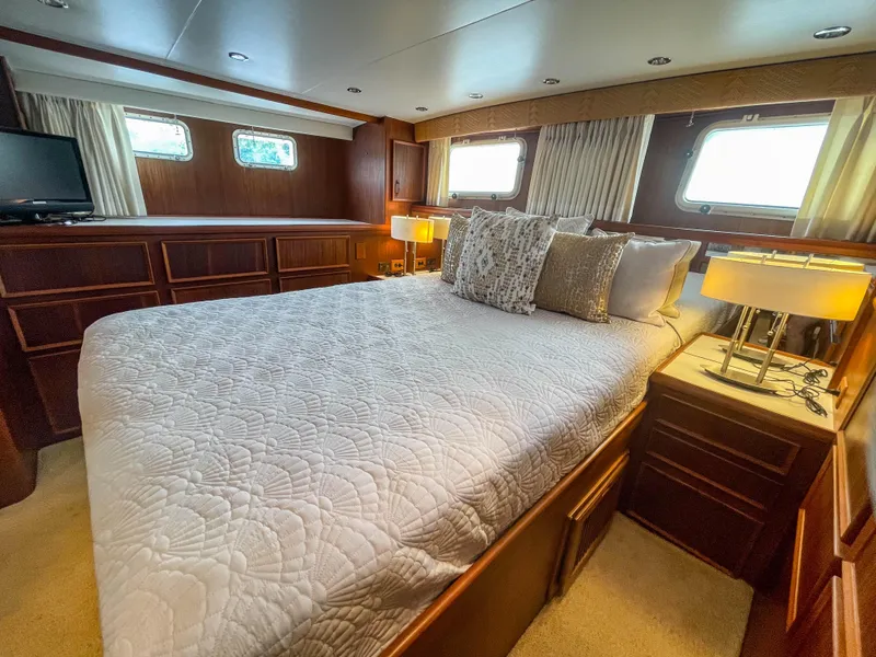 Slide: The Image of Luxurious bedroom interior of 1984 Hatteras 53 Motoryacht with elegant bedding and wood finish. - 48