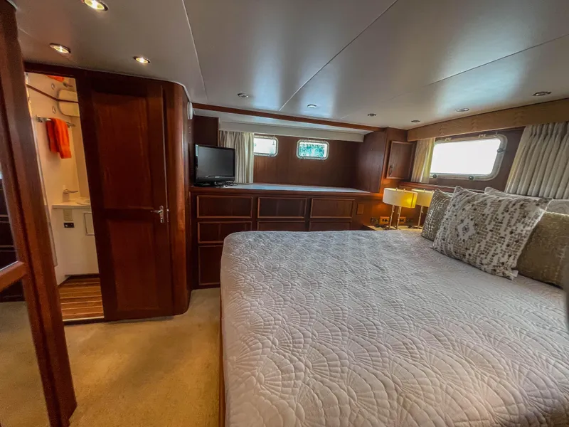 Slide: The Image of Luxurious bedroom interior of 1984 Hatteras 53 Motoryacht with wood paneling and large bed. - 49