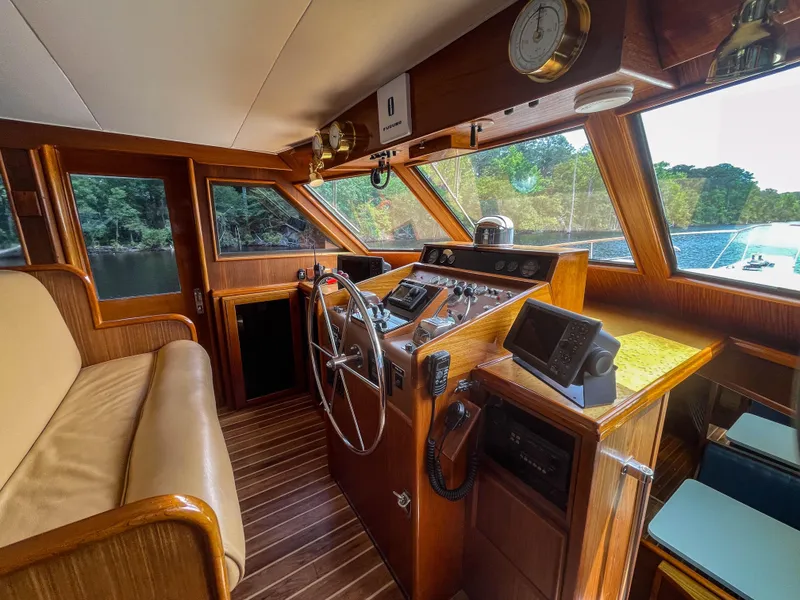 Slide: The Image of 1984 Hatteras 53 Motoryacht helm with wooden interior, steering wheel, and navigation equipment. - 9
