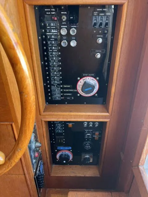 Slide: The Image of Control panel of a 1981 Grand Banks 36 Classic boat, featuring various switches and dials. - 13