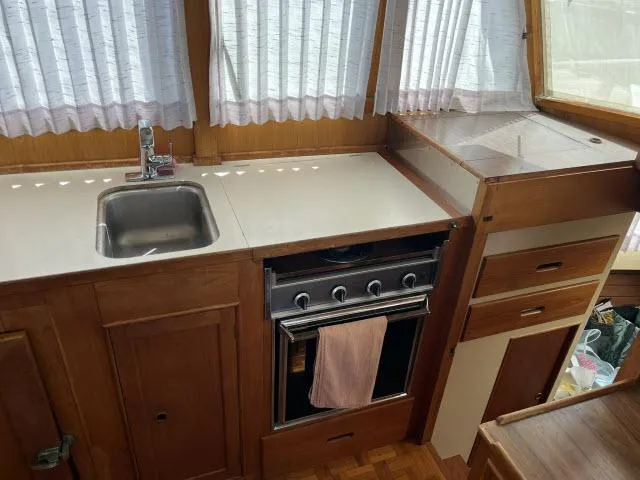 Slide: The Image of 1981 Grand Banks 36 Classic kitchen with sink, stove, and wooden cabinetry. - 17