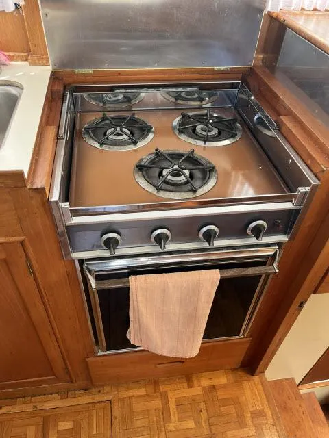 Slide: The Image of 1981 Grand Banks 36 Classic kitchen with a four-burner stove and oven. - 20