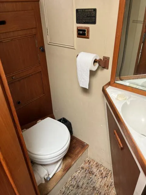 Slide: The Image of 1981 Grand Banks 36 Classic yacht bathroom with toilet, sink, and wooden cabinetry. - 30