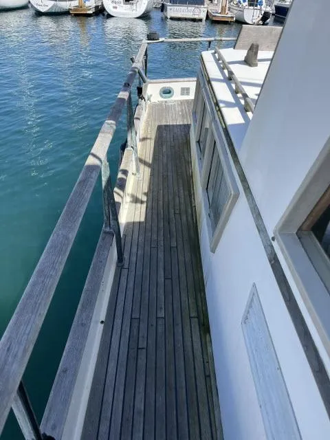 Slide: The Image of 1981 Grand Banks 36 Classic yacht deck with wooden railings and marina view. - 34