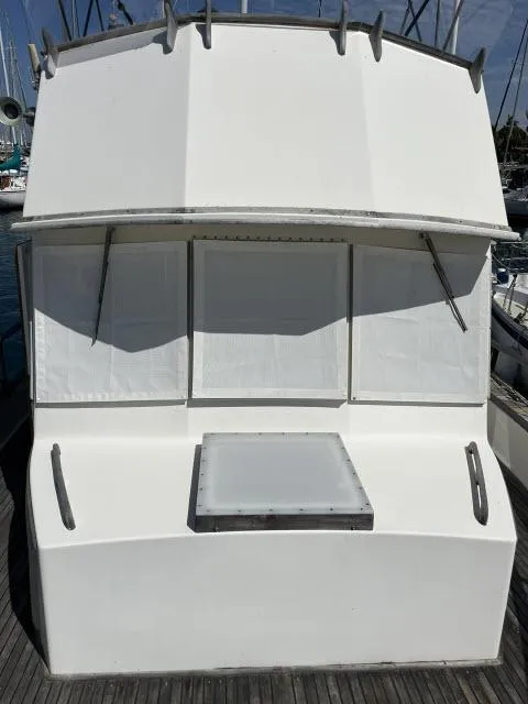 Slide: The Image of 1981 Grand Banks 36 Classic boat with white exterior and covered windows at a marina. - 37