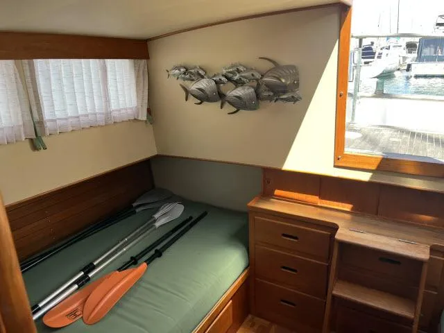 Slide: The Image of 1981 Grand Banks 36 Classic cabin interior with bed, paddles, and fish wall art. - 6