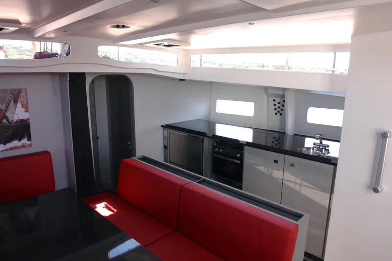 Slide: The Image of Modern yacht interior with red seating, sleek kitchen, and ample natural light, Black Pepper Code 2, 2025. - 20