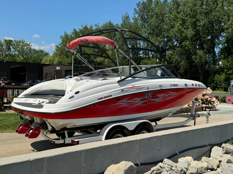 Slide: The Image of 2006 Yamaha AR 210 boat on trailer, red and white design, parked outdoors. - 4