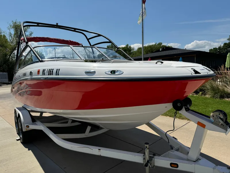 Slide: The Image of 2006 Yamaha Boats AR 210 on trailer, red and white, parked outdoors under clear sky. - 5