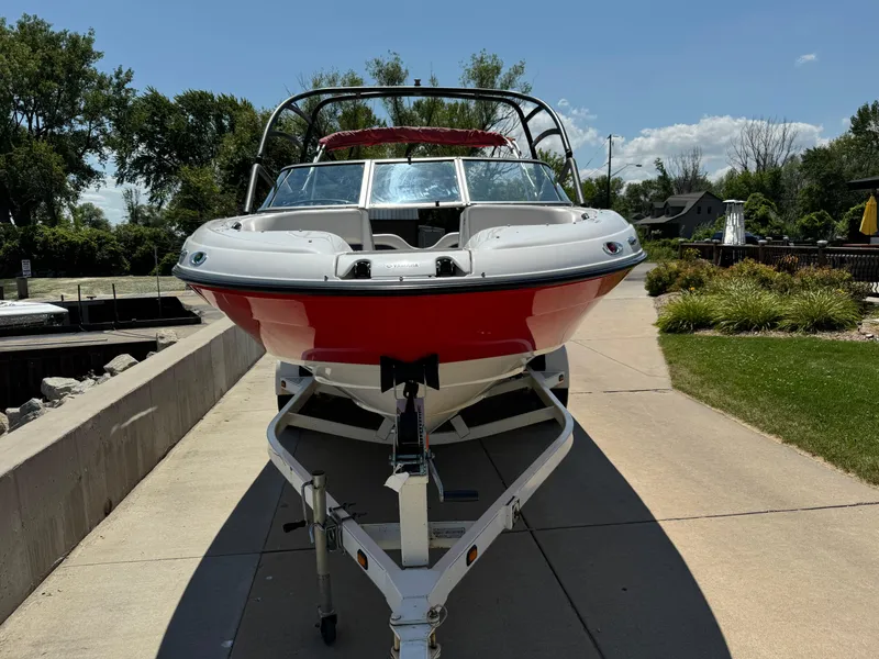 Slide: The Image of 2006 Yamaha Boats AR 210 on trailer, red and white, parked outdoors on sunny day. - 7