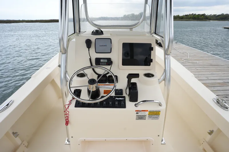 Slide: The Image of Control console of a 2012 Parker 21 SE CC boat, featuring steering wheel and navigation equipment. - 17