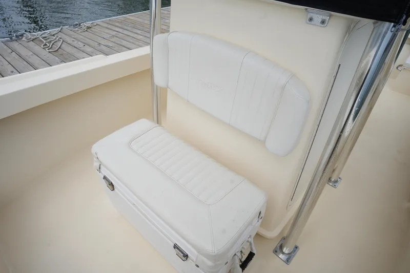 Slide: The Image of 2012 Parker 21 SE CC boat seat with white cushioned backrest and storage compartment. - 26