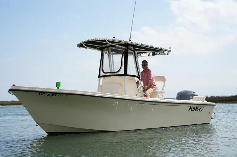 Slide: The Image of 2012 Parker 21 SE CC boat on water with person at helm, clear sky background. - 6