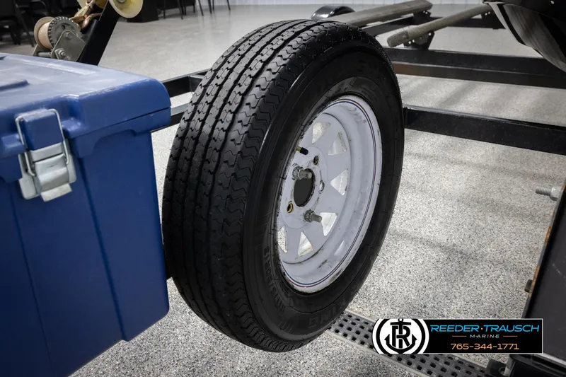 Slide: The Image of 2015 Sea-Doo 215 WAKE PRO trailer tire and blue storage box in garage setting. - 32