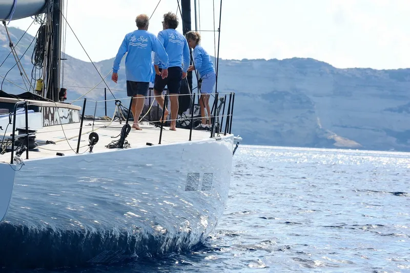 Slide: The Image of Sailboat "Black Pepper Code 3" 2025 model with crew, sailing near rocky coastline. - 10