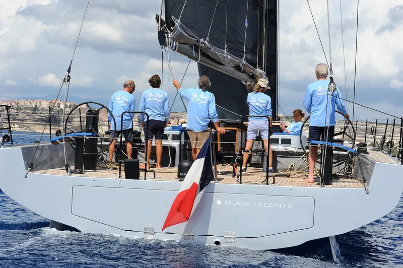 Slide: The Image of Sailboat "Black Legend 4" with crew in blue shirts on open sea. - 12