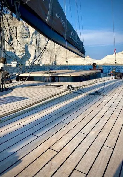 Slide: The Image of Sailing yacht "Black Pepper Code 3" on serene waters near rocky cliffs, 2025 model. - 2