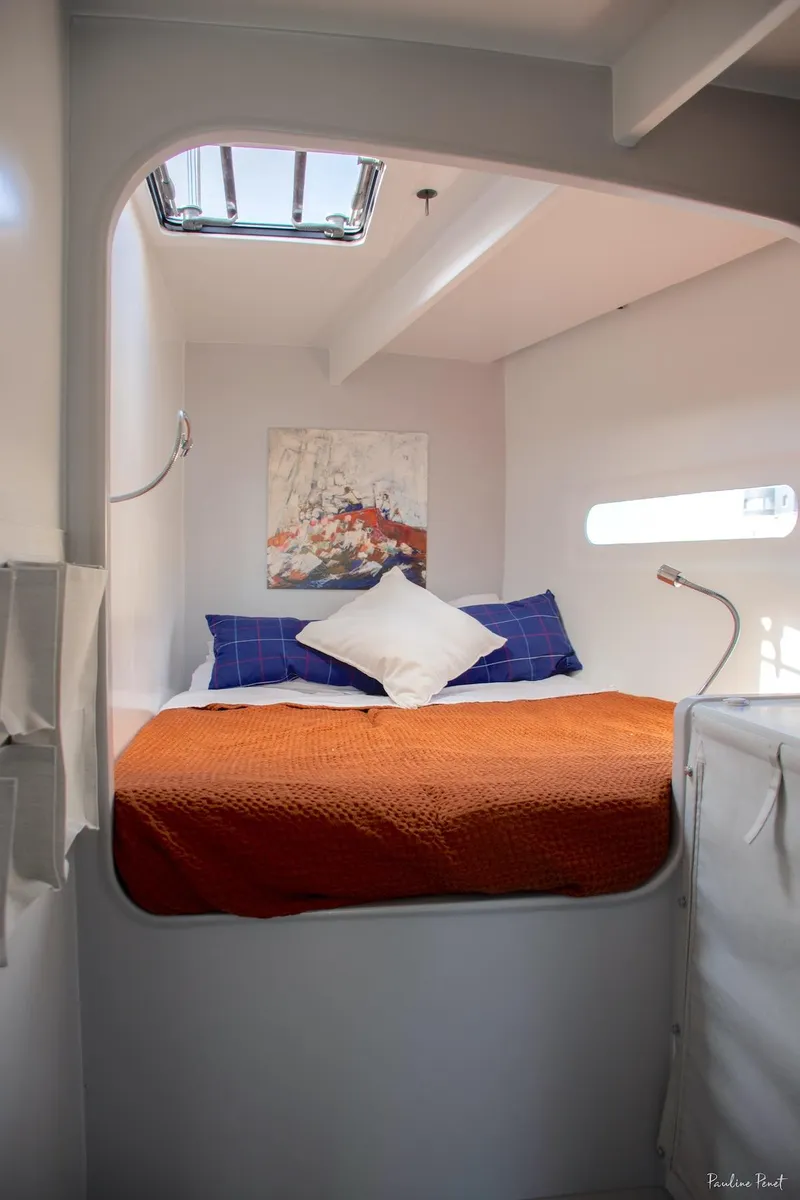 Slide: The Image of Cozy cabin interior with orange bedding, modern decor, and natural light from a skylight. - 21