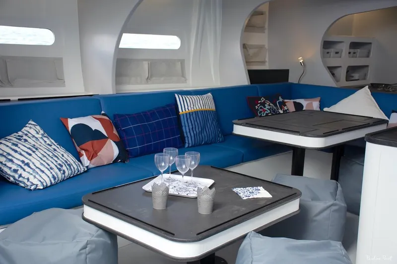 Slide: The Image of Luxurious yacht interior with blue seating, colorful cushions, and modern dining area. Black Pepper Code 3, 2025. - 22