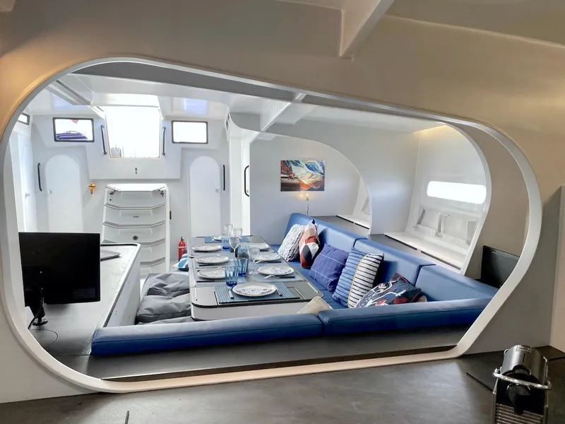 Slide: The Image of Modern yacht interior with blue seating, dining table, and nautical decor, Black Pepper Code 3, 2025. - 28