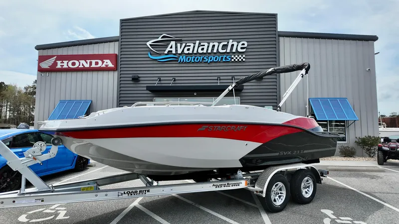 Slide: The Image of 2025 Starcraft SVX 211 IO boat on trailer at Avalanche Motorsports dealership. - 1