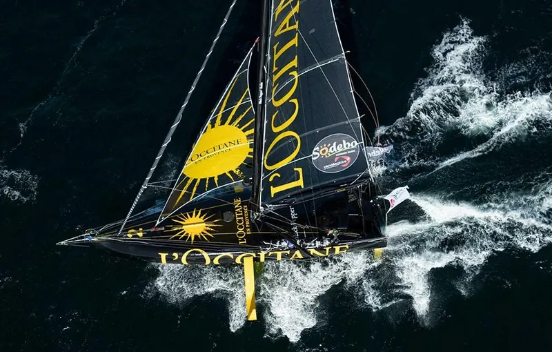 Slide: The Image of Sailing yacht "Black Pepper Imoca 2025" navigating through ocean waves, featuring L'Occitane branding. - 1