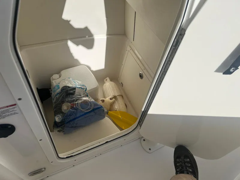 Slide: The Image of Storage compartment in a 2018 Century 2301 Center Console boat with various items inside. - 9