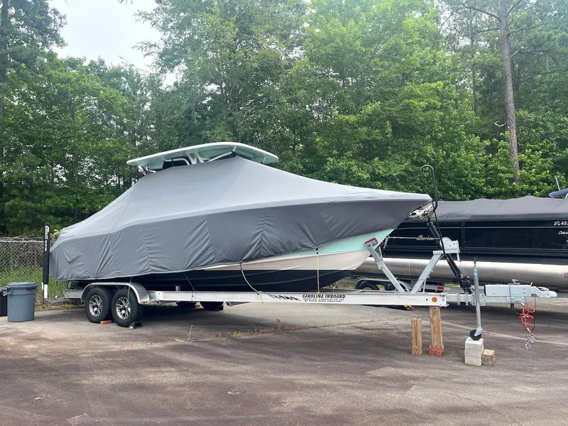 Slide: The Image of 2022 Key West 263 FS boat covered on trailer, parked outdoors. - 1