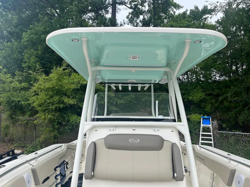 Slide: The Image of 2022 Key West 263 FS boat with T-top and seating, surrounded by trees. - 10