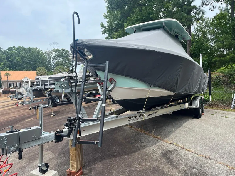 Slide: The Image of 2022 Key West 263 FS boat covered on a trailer in a parking area. - 4