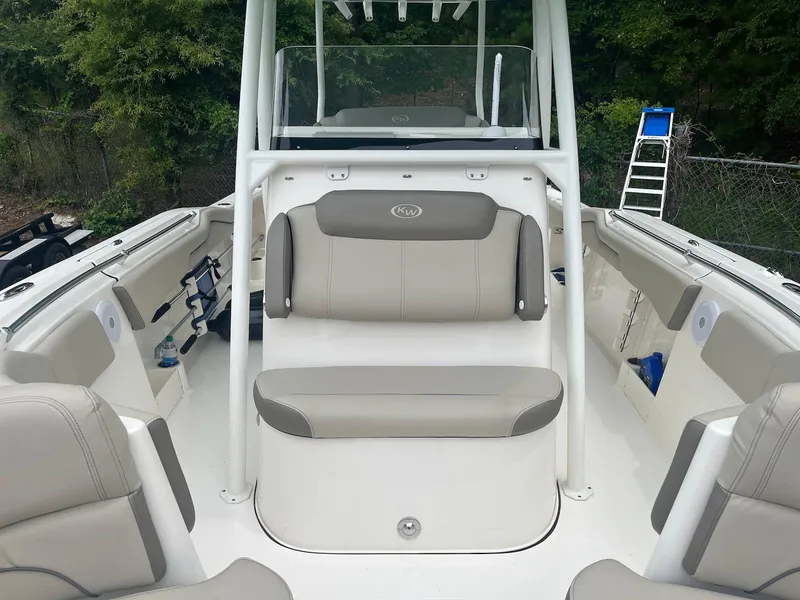 Slide: The Image of 2022 Key West 263 FS boat interior with seating and console, surrounded by lush greenery. - 9