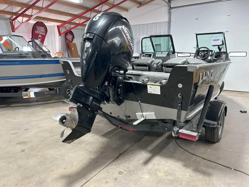 Slide: The Image of 2021 Lund 1875 Impact XS boat with Mercury outboard motor in a garage setting. - 5